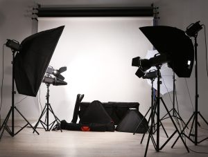 Empty Photo Studio With Lighting Equipment, Bags And Backdrop