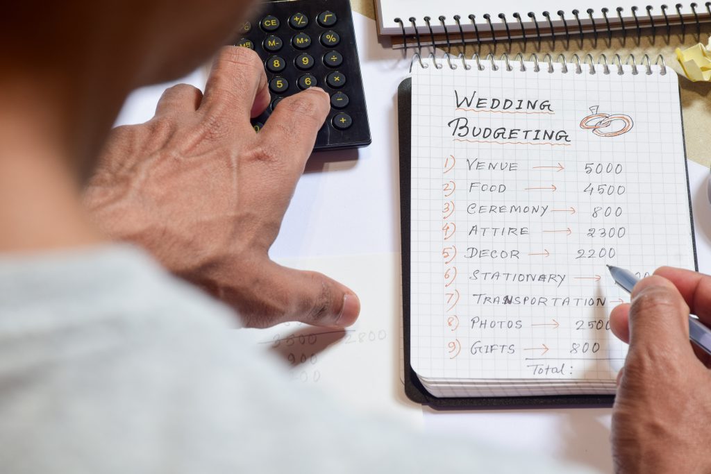 Man Calculating Wedding Expenses On Notepad. Selective Focus.